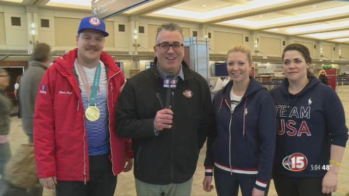 Olympic gold medal curler Matt Hamilton in his Arctica Comp Jacket with WMTV NBC15 Sports Director Mike Jacques in the airport as they arrive home from PyeongChang.